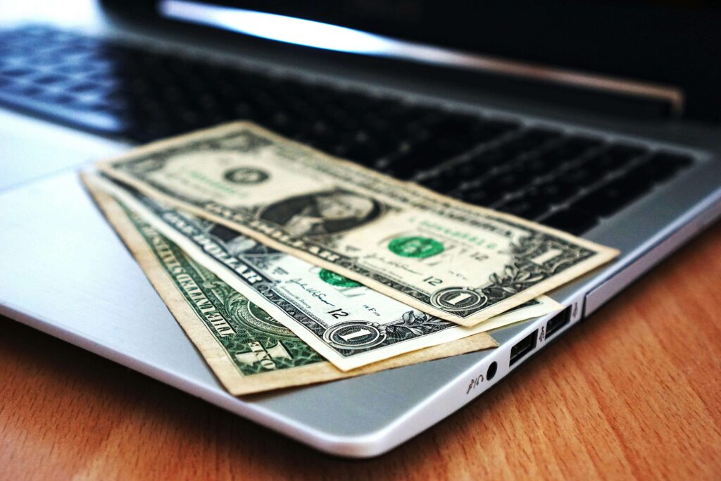 Dollar bills placed on top of a laptop keyboard