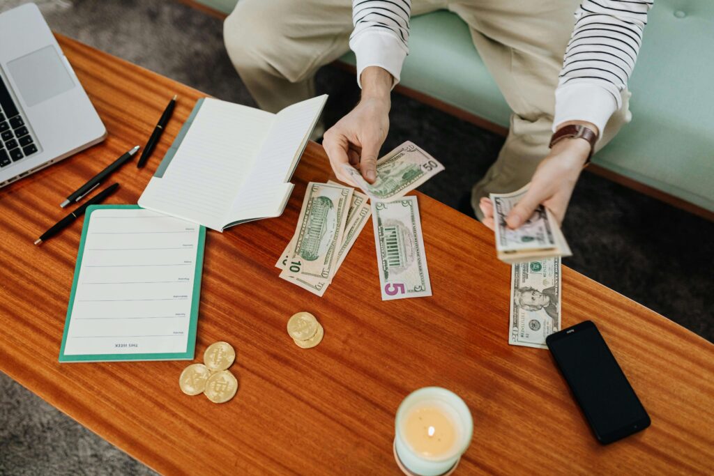 A man counting some paper bills while sitting on the sofa