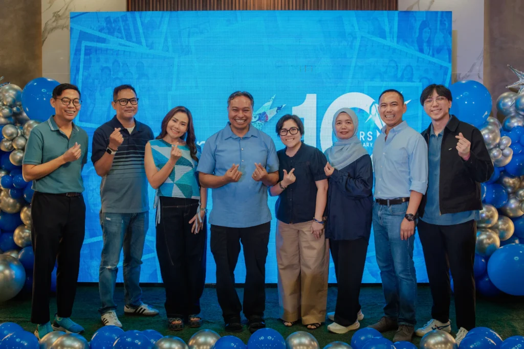 BCRemit executive board posing together at the company’s 10th anniversary celebration in front of a blue “10 Years” event backdrop and balloon display.